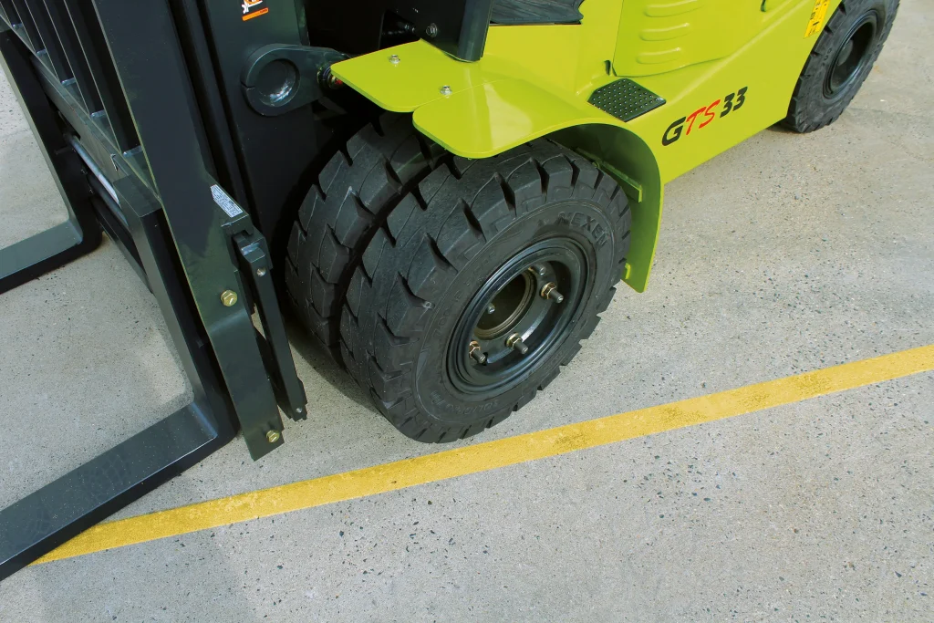 Ruedas delanteras de la carretilla elevadora Clark GTS33 con neumáticos resistentes y estructura reforzada.