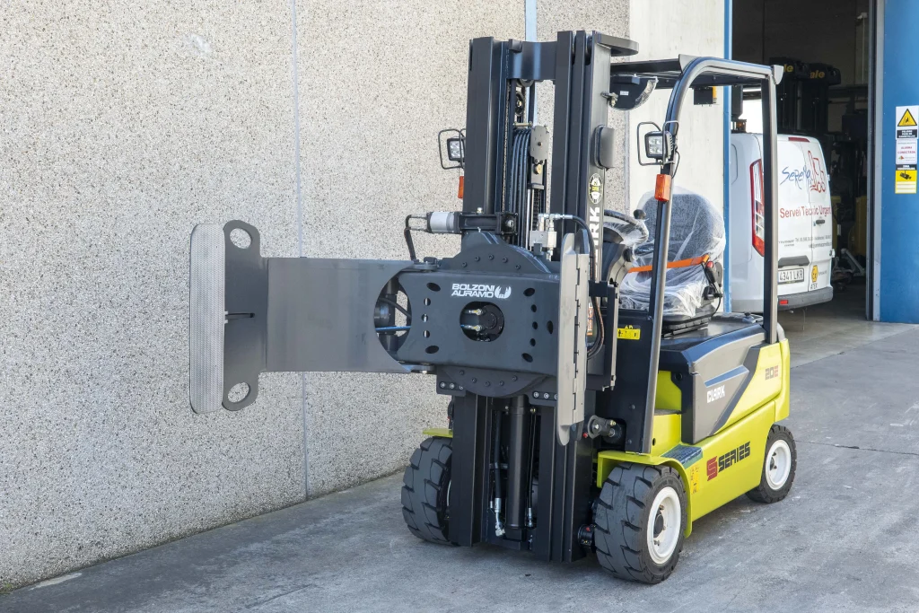 Carretilla elevadora Clark Serie S equipada con pinzas Bolzoni Auramo para la manipulación de bobinas en un entorno industrial.