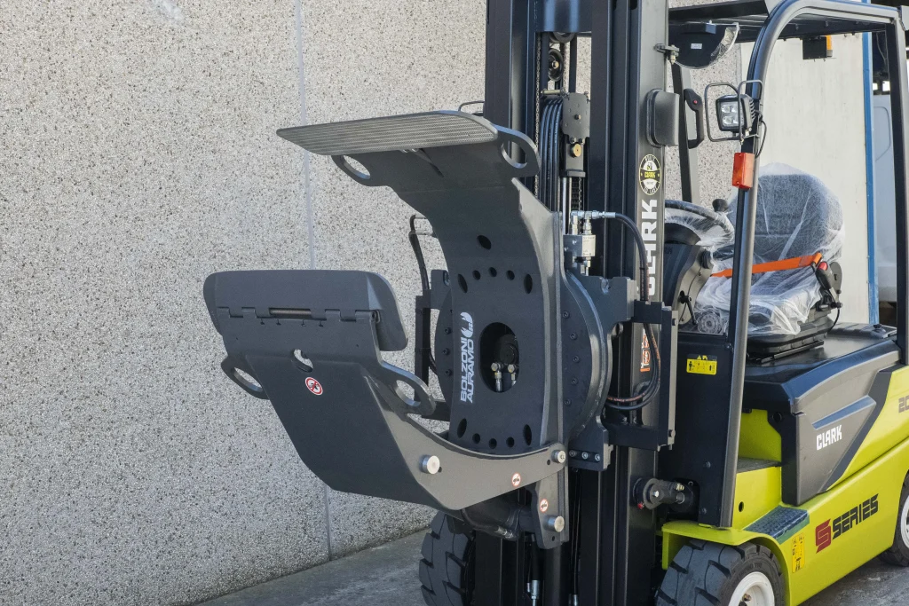 Carretilla elevadora Clark equipada con pinzas Bolzoni Auramo, diseñada para la manipulación de bobinas en operaciones industriales.